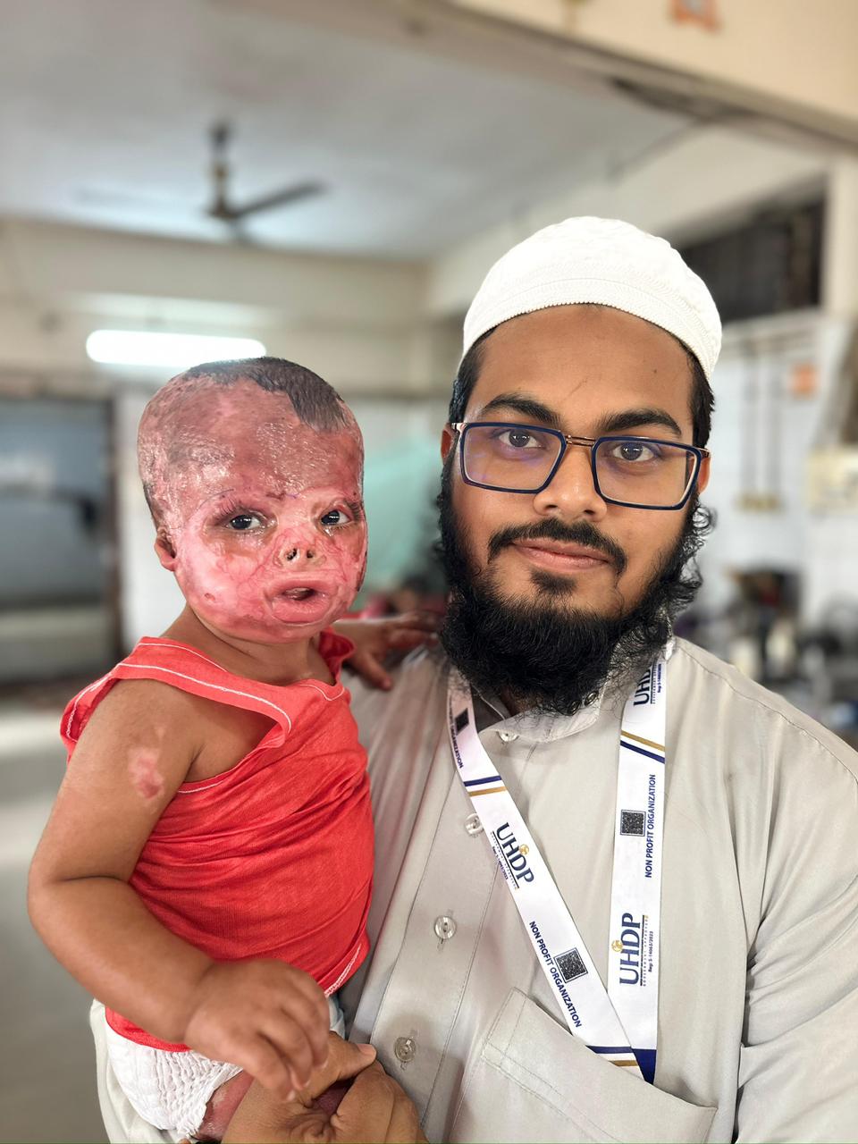 UHDP caregiver holding a child receiving medical support